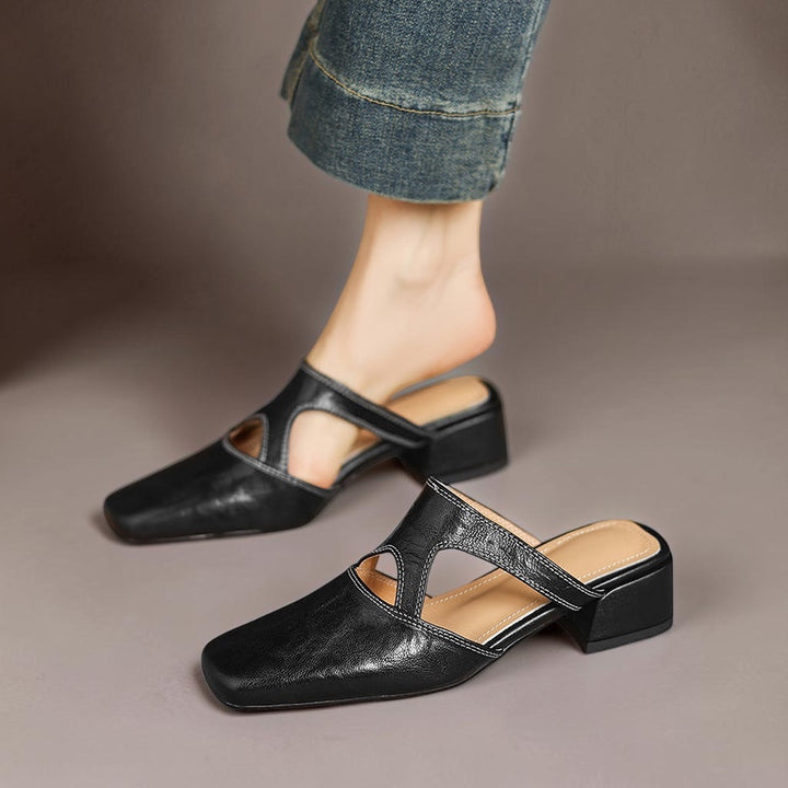 Vivian &amp; Cole Dessa black genuine leather mules with square toe, cut-out detailing, and a comfortable block heel.