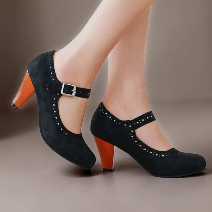 Vivian &amp; Cole Genevieve black Mary Jane heels with a rounded toe, adjustable strap, and contrasting orange block heel.
