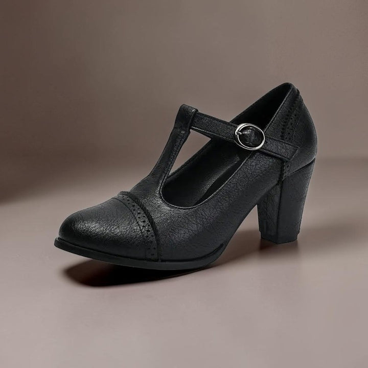 Vivian &amp; Cole black T-strap brogue heels with a steady block heel and classic punched detailing on a neutral background
