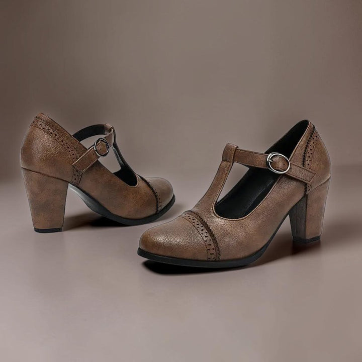 Vivian &amp; Cole brown T-strap brogue heels with a steady block heel and classic punched detailing on a neutral background