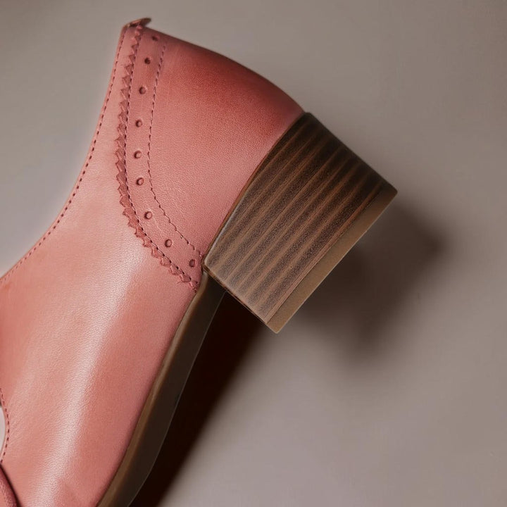 Vivian &amp; Cole pink leather oxford shoe featuring intricate carved detailing and a sturdy low block heel.