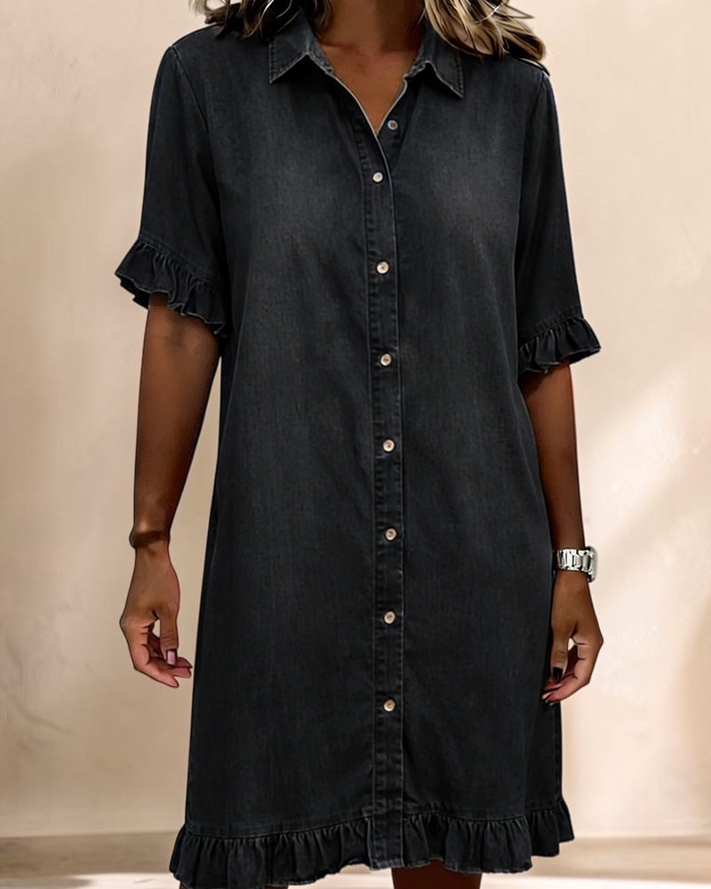 Vivian & Cole black denim smocked waist dress with a button-down front, collar, and ruffled sleeve and hem details.