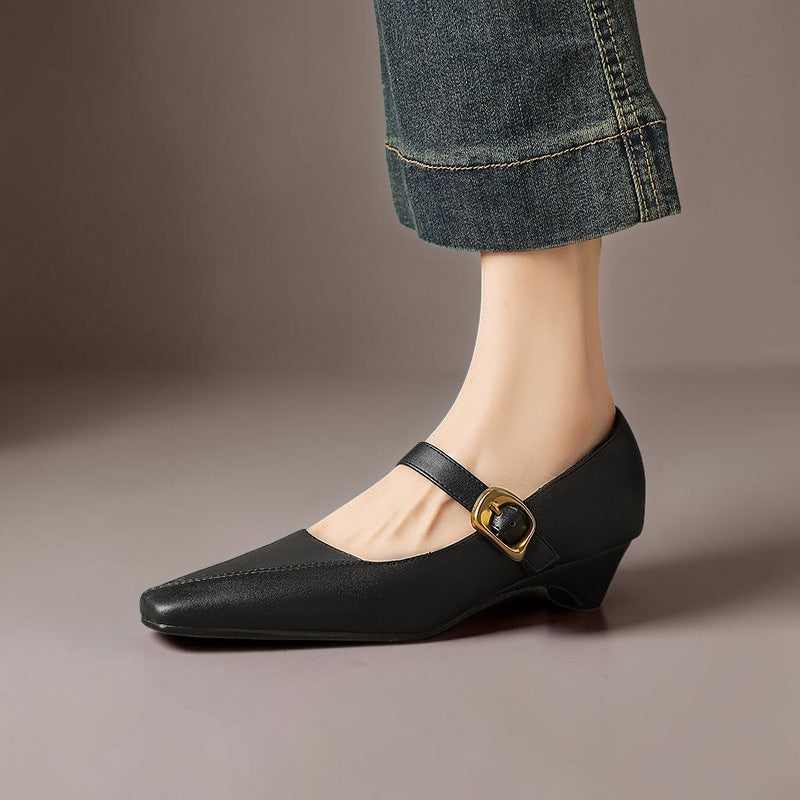 Vivian &amp; Cole black leather Mary Jane heels with paneled construction, gold-tone buckle, and low block heel.