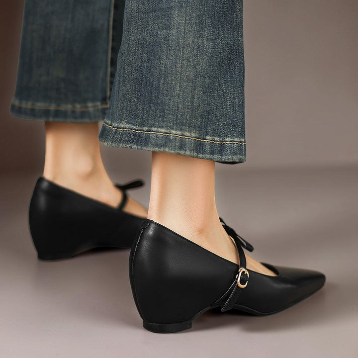 Vivian &amp; Cole black leather Mary Jane pumps featuring a bow-strap and a concealed block heel worn with denim jeans.