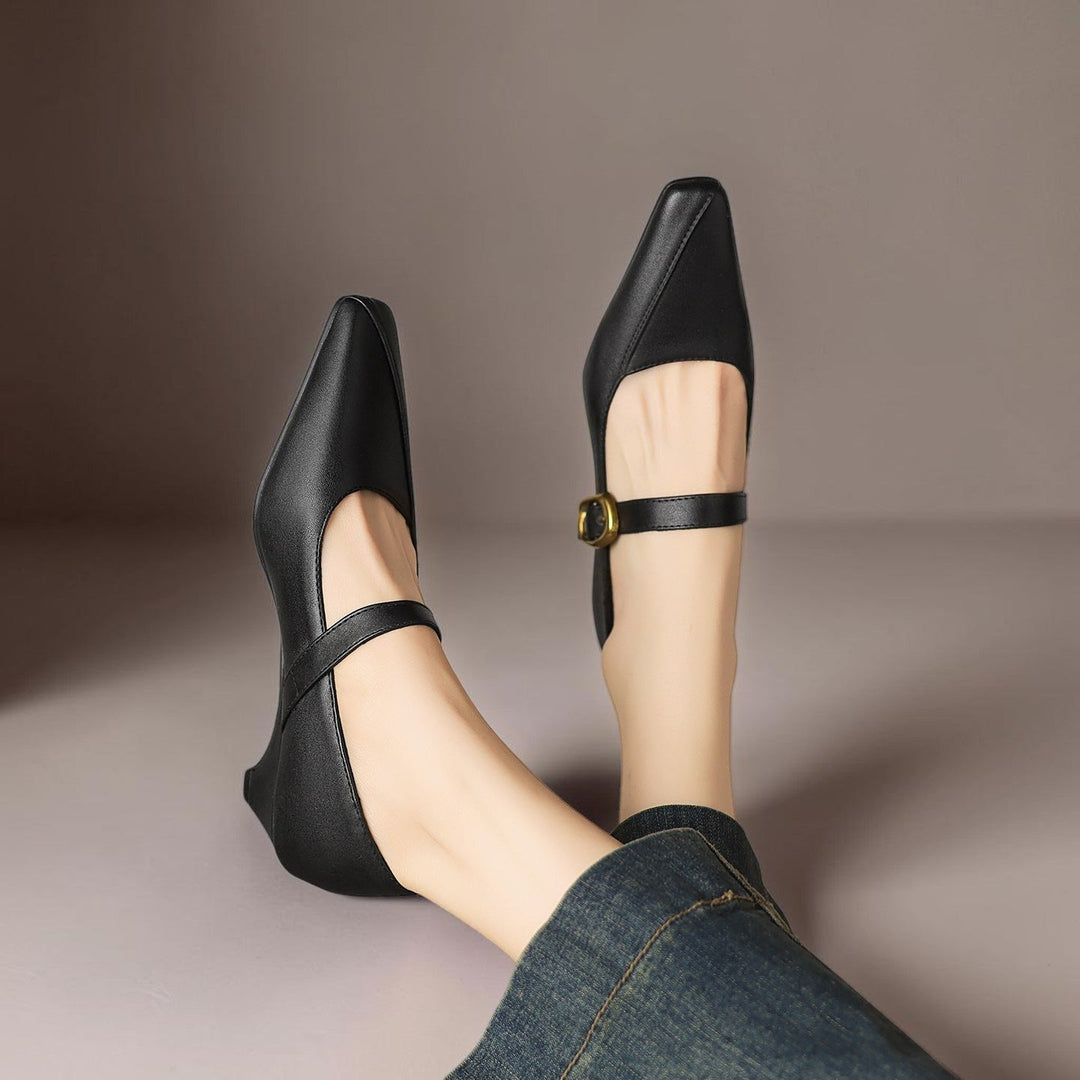Vivian &amp; Cole black leather paneled Mary Jane heels with a gold-tone buckle and low block heel worn on feet