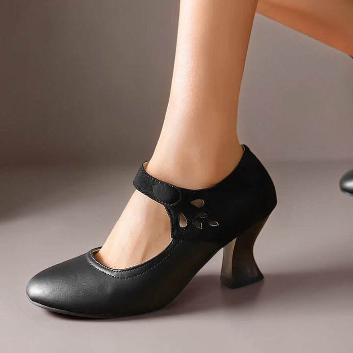 Vivian &amp; Cole Antonia black round-toe heels with a stable flared heel, ankle strap, and decorative cutout detail.
