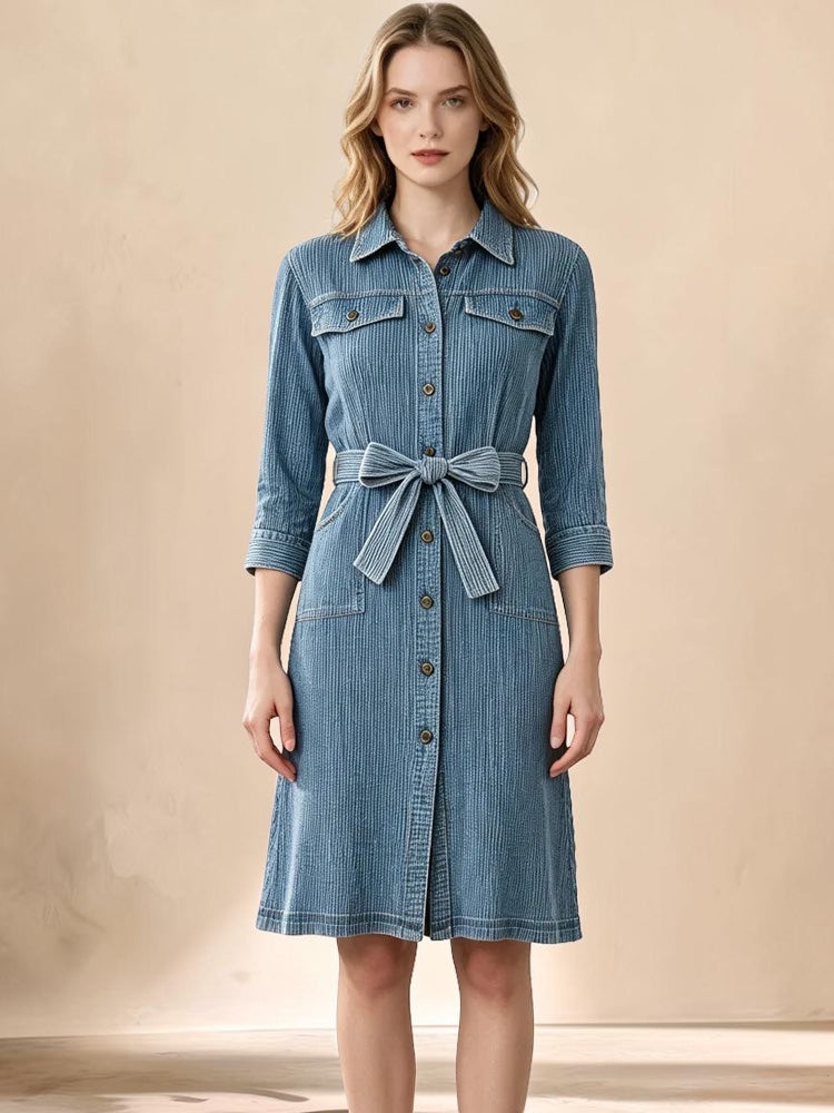 Vivian &amp; Cole Delphine midi dress in blue corduroy-textured denim with a button-down front and matching waist tie.