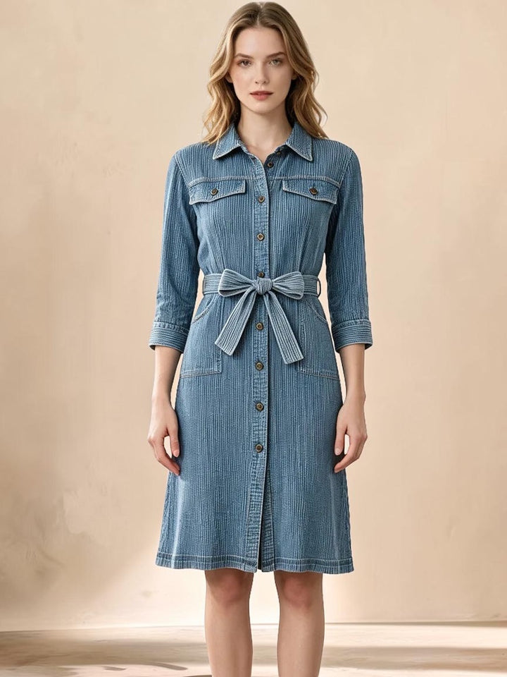 Vivian &amp; Cole Delphine midi dress in blue corduroy-textured denim with a button-down front and matching waist tie.