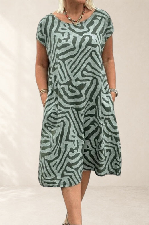 Vivian & Cole Calyviah A-line dress in sage green with abstract zebra print, short flared sleeves, and pockets.
