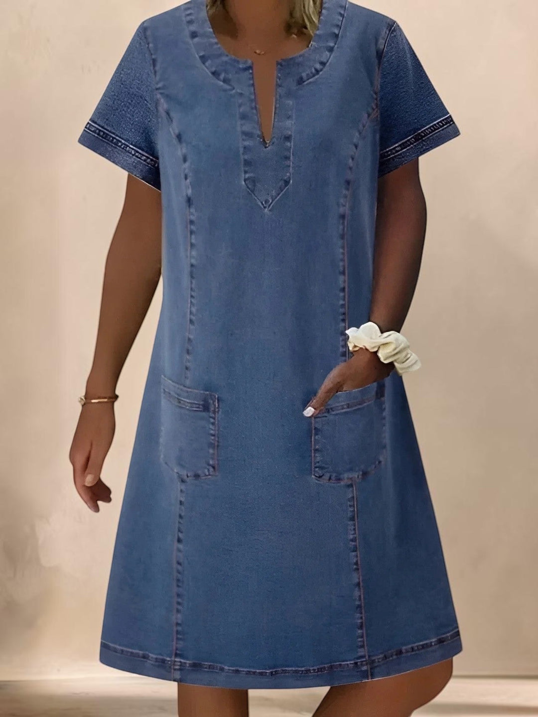 Vivian & Cole Christine denim dress featuring a V-neck, short sleeves, and functional front pockets in medium blue.