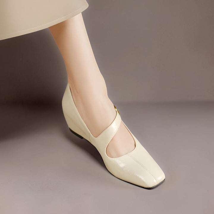 Vivian &amp; Cole Viora cream genuine leather Mary Jane heels with a square toe, tilted buckle strap, and wedge sole.