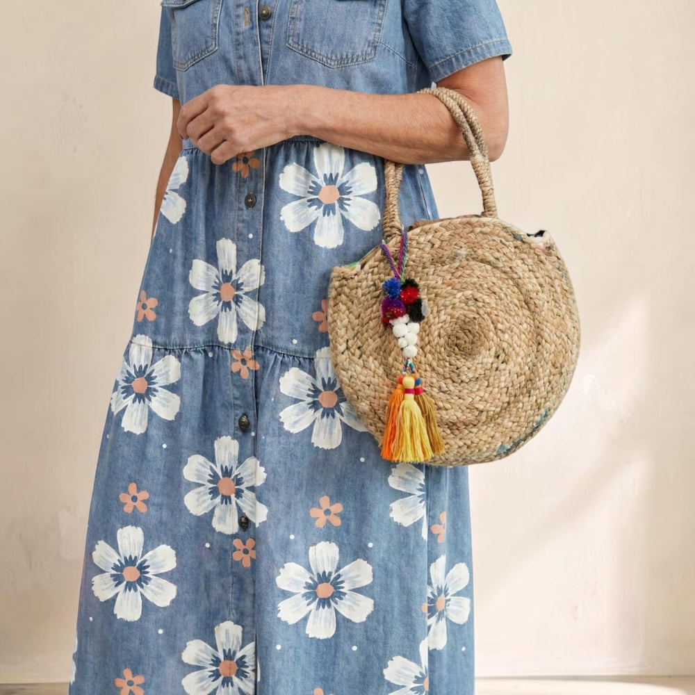 Vivian & Cole Kirra denim shirt dress with white floral print and button front paired with a round straw bag