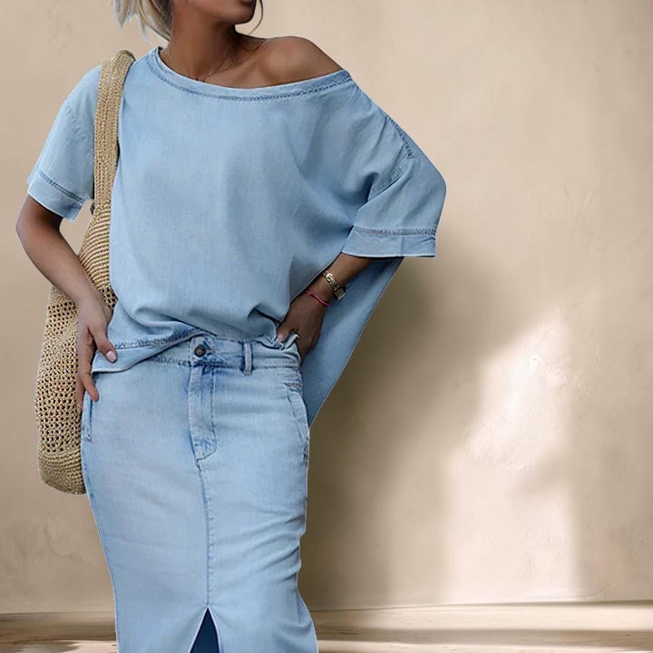 Vivian &amp; Cole light wash denim maxi skirt set featuring an asymmetrical shoulder top and a front split skirt.