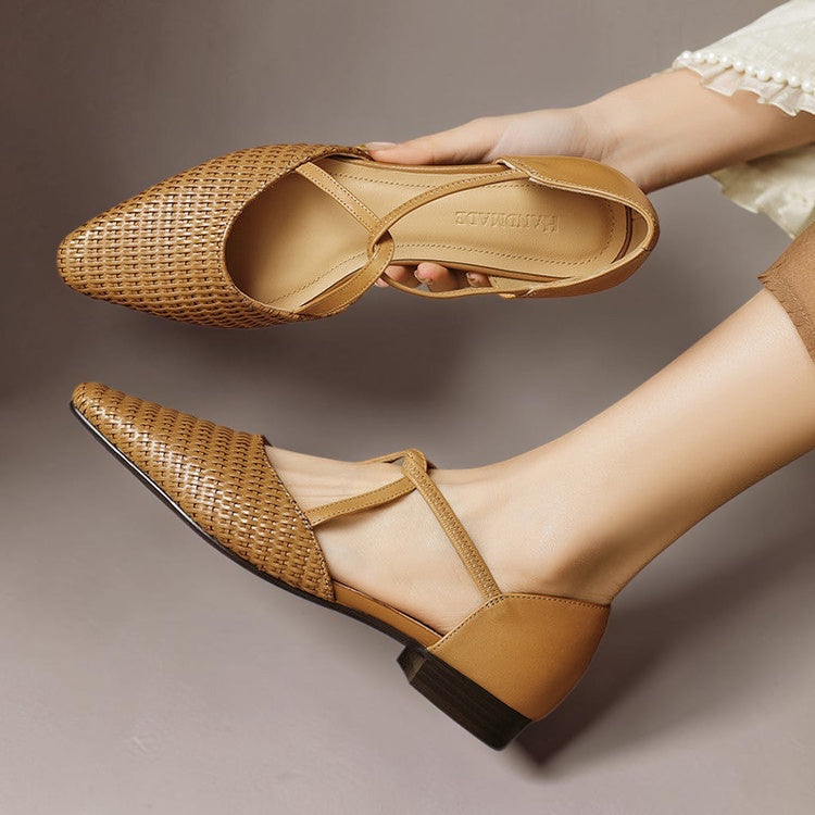 Vivian & Cole Dona tan woven leather pointed-toe T-strap flats with a low block heel held by a person