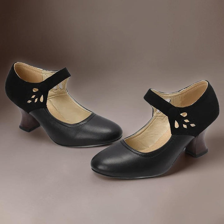 Vivian &amp; Cole Guinevere black Victorian style heels with ankle strap, cutout detail, and stable wooden-look heel.