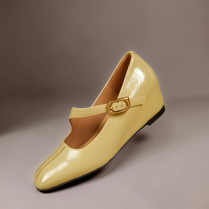 Vivian &amp; Cole Viora glossy cream leather Mary Jane heels with a square toe, tilted buckle strap, and concealed wedge.
