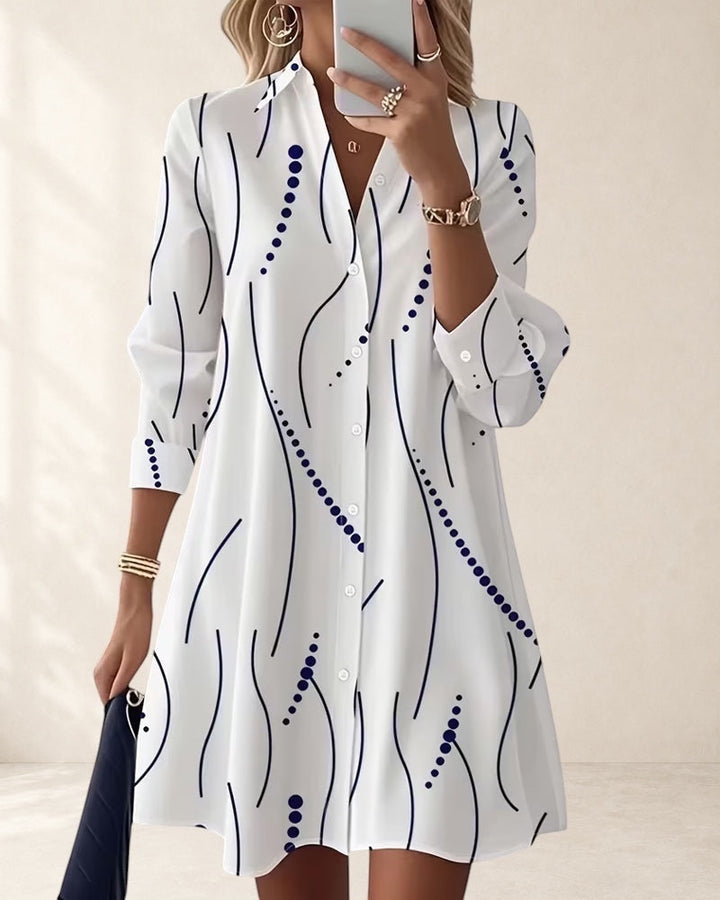 Vivian &amp; Cole white A-line dress with wavy blue stripe pattern, lapel collar, long sleeves, and button front. Above knee length.